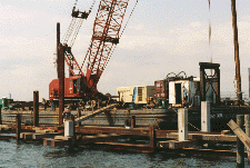 Manitowoc 4100 on barge, piles in the foreground with falsework
